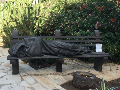 Statue of Jesus as a poor person sleeping on bench